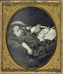 Antique Victorian post-mortem daguerrotype of a child with her doll who was said to be haunted after the child's death